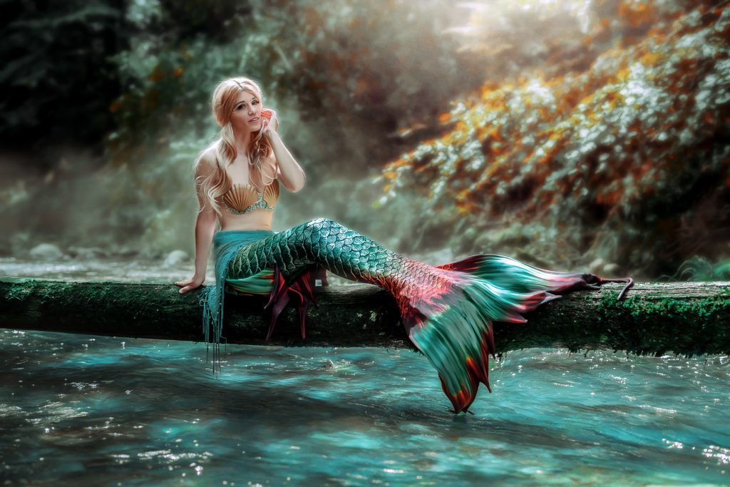 Mermaid mit rosa-grüner Flosse in mystischer Lichtstimmung