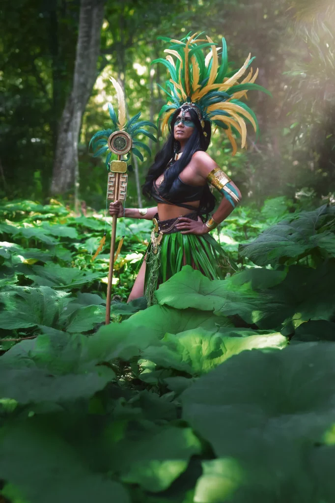 Azteca Warrior – Azteken-Kriegerin im Dschungel mit Ritualstab, traditionellem Federschmuck und Rauchnebel, Fantasy Fotoshooting inspiriert von südamerikanischer Kultur.