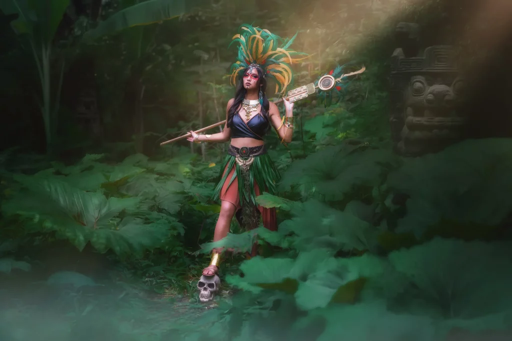 Aztekenkriegerin hebt ihren Ritualstab im nebligen Wald, durchzogen von Lichtstrahlen – Szene aus dem Azteca Warrior Fantasy Fotoshooting von Elena Frizler Photography in der Schweiz.