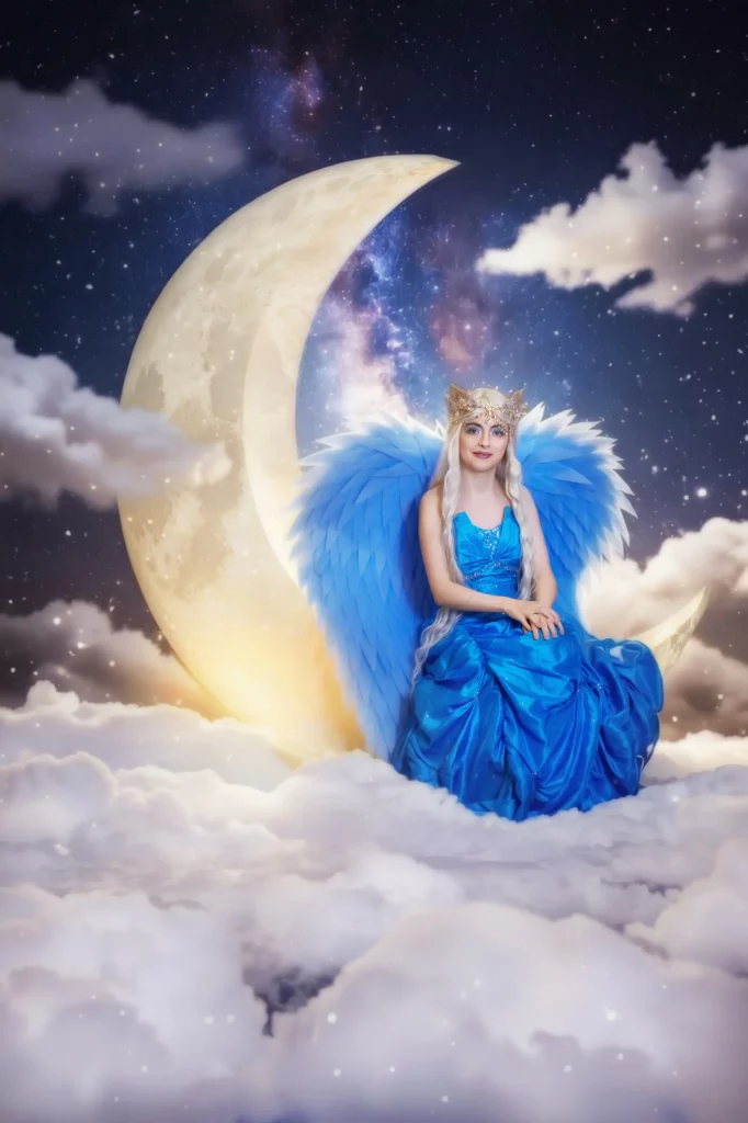 Blauer Engel mit Engelsfluegel und blauem Kleid sitzend auf dem Mond Nacht Szene ueber den Wolken Studio Set Fantasy Lunara Elena Frizler Photography