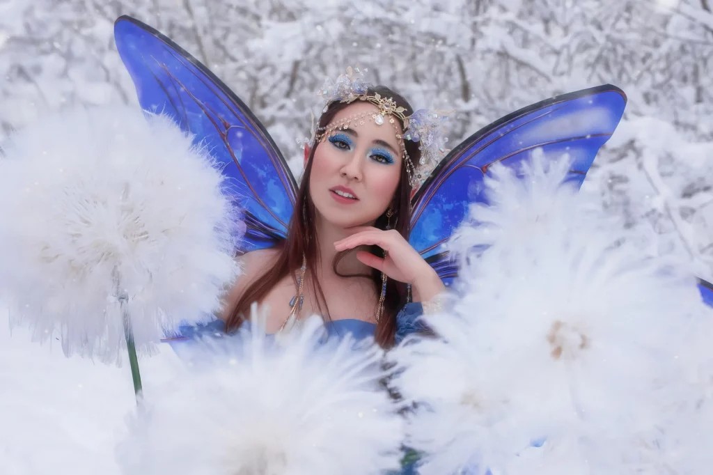 Fantasy Fairy Portrait Fotoshooting Entlebuch Luzern Model mit Feenfluegeln im Schnee zwischen Pusteblumen