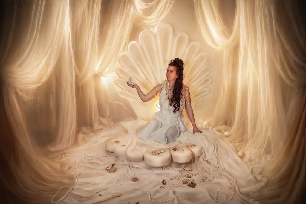 Frau im Venus-Reborn-Studio-Set auf Muschelthron mit Perle in der Hand, inspiriert von der Geburt der Venus